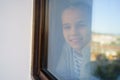 Through glass. happy teen girl look out of window outside. recovered. Royalty Free Stock Photo