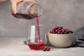 Glass with healthy cranberry juice on light background