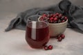 Glass with healthy cranberry juice on light background