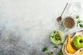 Glass of healthy green smoothie and ingredients for smoothie, fresh spinach, chia seed, pea microgreens, banana, kiwi and apple in Royalty Free Stock Photo