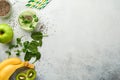 Glass of healthy green smoothie and ingredients for smoothie, fresh spinach, pea microgreens, banana, kiwi, apple and chia seed Royalty Free Stock Photo