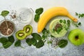 Glass of healthy green smoothie and ingredients for smoothie, fresh spinach, pea microgreens, banana, kiwi, apple and chia seed Royalty Free Stock Photo