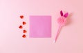 Glass heart, empty lit and a pen on a pink background