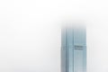 Glass high rise office tower disappears into low clouds in white sky Royalty Free Stock Photo
