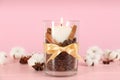 Glass holder with burning candle, coffee beans and cinnamon on pink wooden table Royalty Free Stock Photo