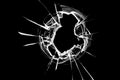 The glass hole shatters on the window from a bullet shot. Broken glass texture on a black background. Royalty Free Stock Photo