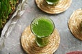 A glass of homemade barley grass juice with freshly grown barleygrass blades Royalty Free Stock Photo