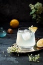 A glass of homemade elderflower gin sour or lemonade garnished with freshly picked elderflowers