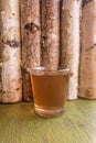 Glass of homemade ginger tincture or ale on a wooden background