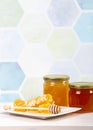 Glass honey jars with different color honey inside, lot of copy space on blue.