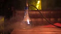 Glass hookah with glass bowl standing on the table in lounge bar. Media. Close up of shisha flask in clouds of smoke on