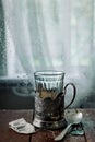 A glass of hot black tea in a vintage cup holder. Wonderful still life. Selective focus. The glass is opposite the window Royalty Free Stock Photo