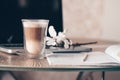 A glass cup with a double bottom with a fragrant hot latte cappuccino stands on the table morning breakfast computer laptop and wo Royalty Free Stock Photo