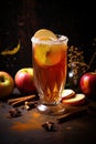 Glass of hot wassail or christmas winter punsh with spices and apples on the dark background