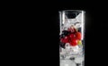 Glass of ice with berry gooseberries red black currants and water. Refreshing cocktail. Summer drink. Royalty Free Stock Photo