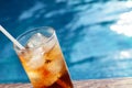 A glass of ice cola at pool with vintage filter background