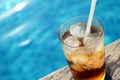 A glass of ice cola at pool with vintage filter background