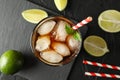 Glass with ice cola and tubule on black background