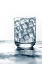 Glass of Ice cube on wooden table and light blurred background Royalty Free Stock Photo