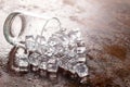 Glass of Ice cube on wooden table and light blurred background Royalty Free Stock Photo