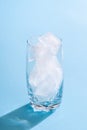 Glass with ice cubes on blue background. Empty glass with ice Royalty Free Stock Photo