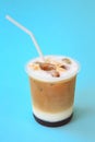 A glass with ice latte coffee cocktail, cold refreshing drink or beverage with ice on blue Royalty Free Stock Photo