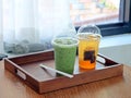 The glass of ice matcha green tea and honey lemon tea on wooden table with see through curtains, feeling fresh and full of energy Royalty Free Stock Photo