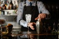 Glass of ice, various bottles of alcoholic drinks and shaker stand at bar. Royalty Free Stock Photo