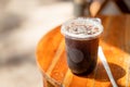 Glass of iced americano coffee on wooden table