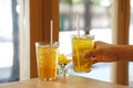 Glass of iced bael fruit herbal drink and Chinese chrysanthemum tea with ice on wooden table.