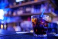 Glass of iced cocktail on bar background. Wiskey in glass with bokeh light on black background