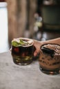 A glass of Iced Cocoa decorated with chocolate cookie and pink flower cool drink served on table.