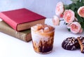 A glass of iced coffee with chocolate cookies and the books. Relaxing moment at home. Royalty Free Stock Photo