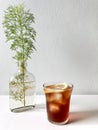 A glass of iced coffee and coriander in flat bottle.
