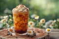 Glass of iced coffee with cream topping on garden