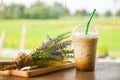 glass of iced coffee on wooden balcony with green nature background Royalty Free Stock Photo