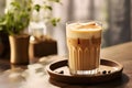 Glass of iced Dalgona Coffee or coffee with milk in kitchen interior, morning atmosphere. Trendy milky coffee latte made of