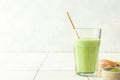Glass of iced green matcha latte with a straw on white tile background Royalty Free Stock Photo