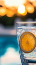 Glass of iced lemon water by the pool at sunset Royalty Free Stock Photo
