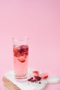 A glass of iced tea with frozen strawberry and lingonberry