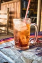 A glass of iced tea in a simple stall is served on the table.