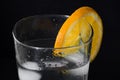 Glass of iced water with an orange slice isolated on a black background Royalty Free Stock Photo