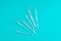 Glass icicles for Christmas tree decor on turquoise background Royalty Free Stock Photo
