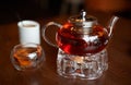 Glass infuser teapot with tea on the trivet and tea cup Royalty Free Stock Photo