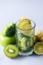 Glass with Ingredients for Fresh Green Smoothie with Kiwi Broccoli Green Apples Babanas and Lime Healthy Detox Blue Background Royalty Free Stock Photo