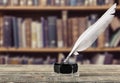 Feather quill pen and glass inkwell on library Royalty Free Stock Photo