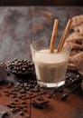 Glass of Irish cream baileys liqueur with cinnamon coffee beans and powder with dark chocolate and brown cloth on dark wood Royalty Free Stock Photo