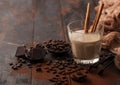 Glass of Irish cream baileys liqueur with cinnamon coffee beans and powder with dark chocolate and brown cloth on dark wood Royalty Free Stock Photo