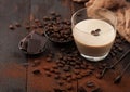 Glass of Irish cream baileys liqueur with coffee beans and powder with dark chocolate and brown cloth on dark wood background Royalty Free Stock Photo