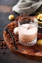 Glass of Irish cream baileys liqueur with ice, roasted coffee beans, cinnamon, Christmas decoration and chocolate on dark wood Royalty Free Stock Photo